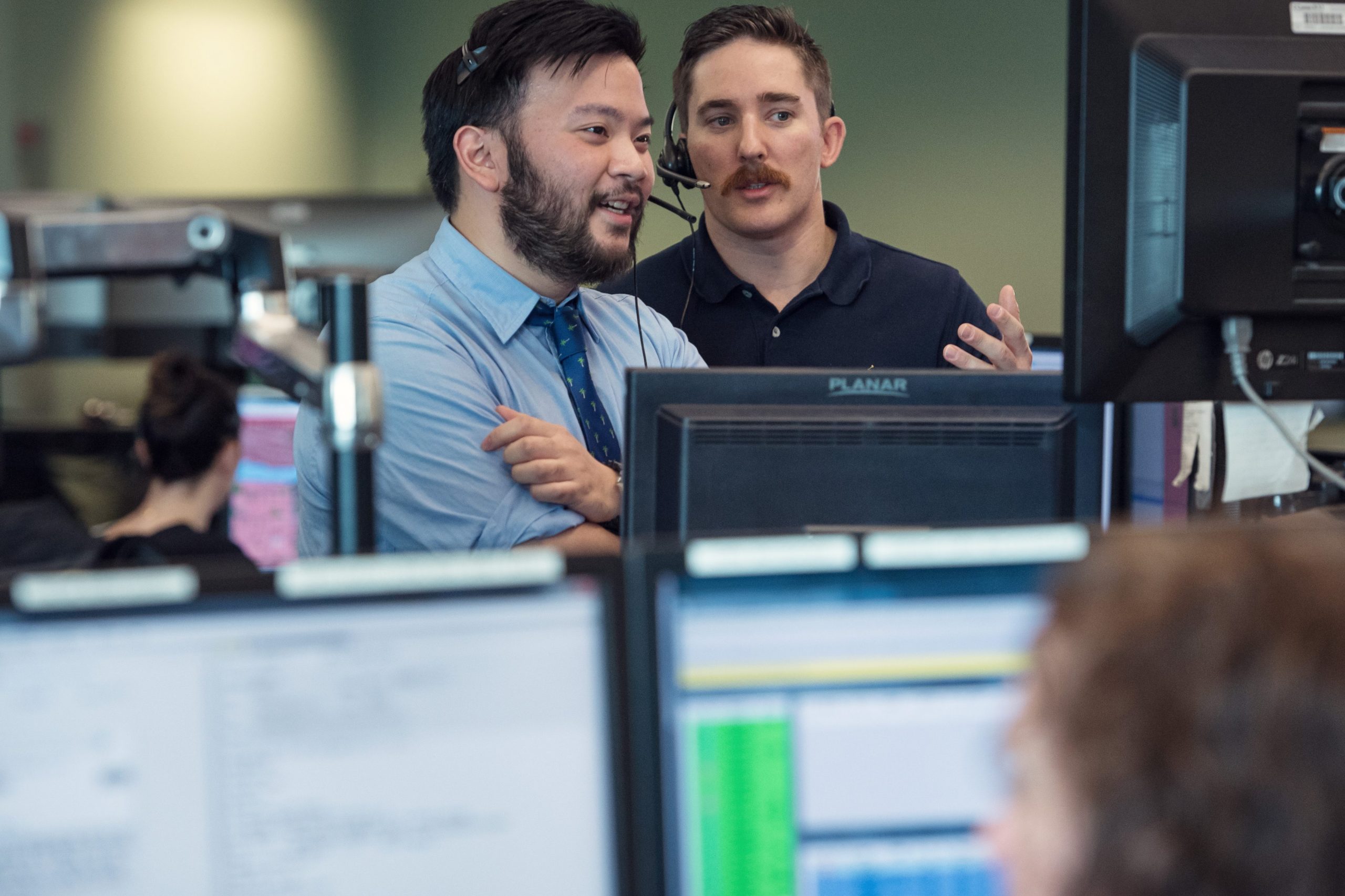 Two men at a call center looking at a monitor