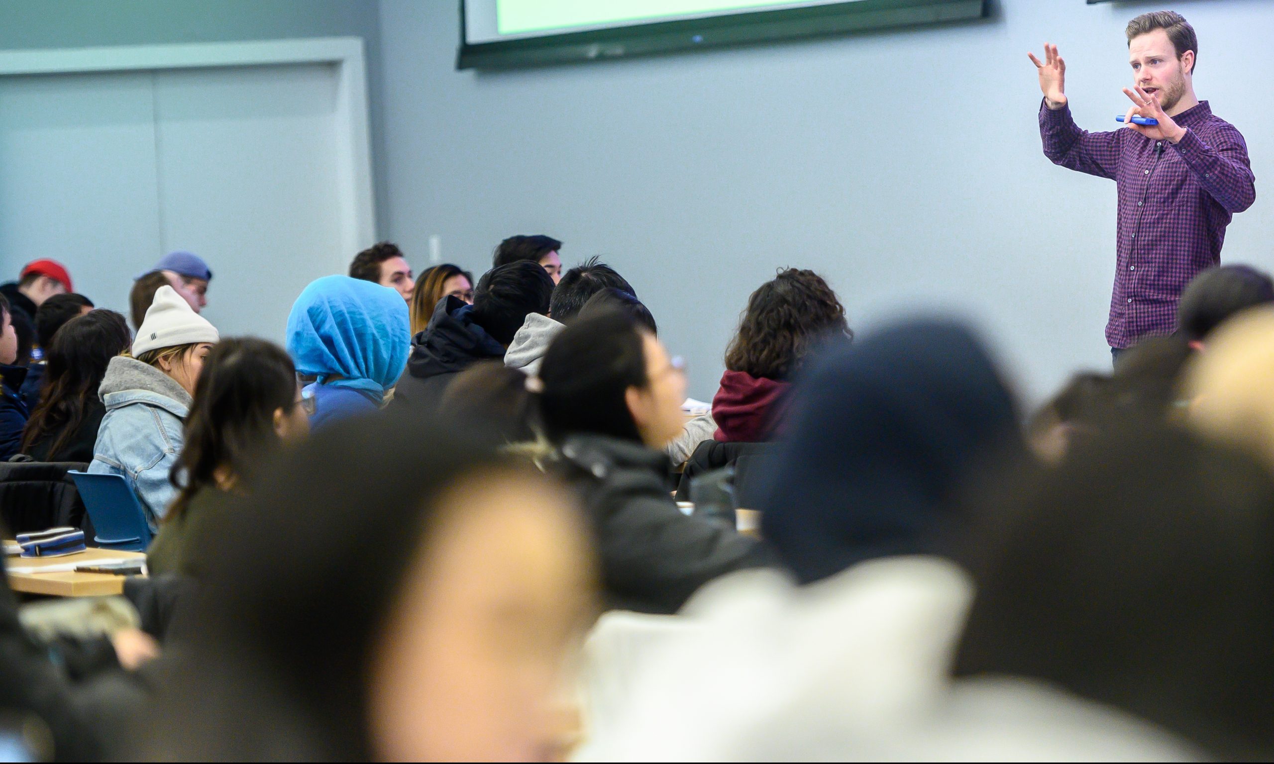 A UBC professor standing at the front of a room teaching students.